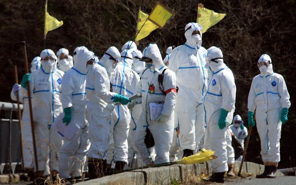 Policemen in radiation proof suits gather to search for missing victims in Namie, Fukushima prefecture. - Sputnik International
