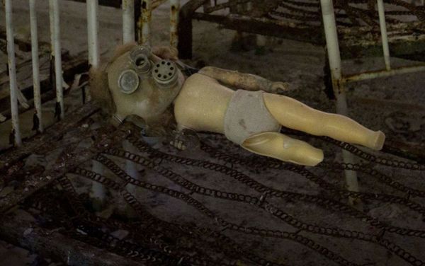 A doll with a gas mask lies on the frame of a bed in the sleeping room of a kindergarten in the deserted town of in Pripyat. - Sputnik International