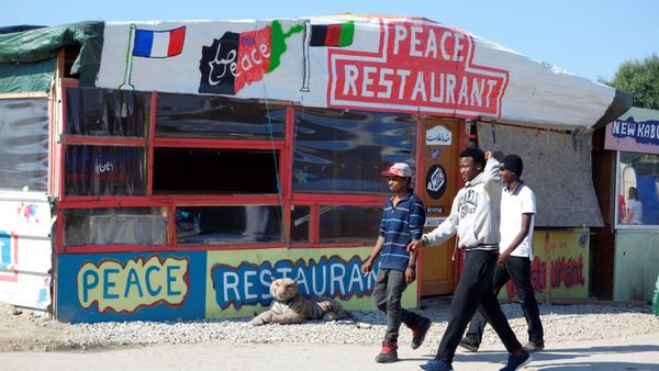 Migrants pass by the Peace Restaurant in the northern area of the camp called the Jungle in Calais, France, September 7, 2016 Migrants pass by the Peace Restaurant in the northern area of the camp called the Jungle in Calais, France, September 7, 2016 - Sputnik International