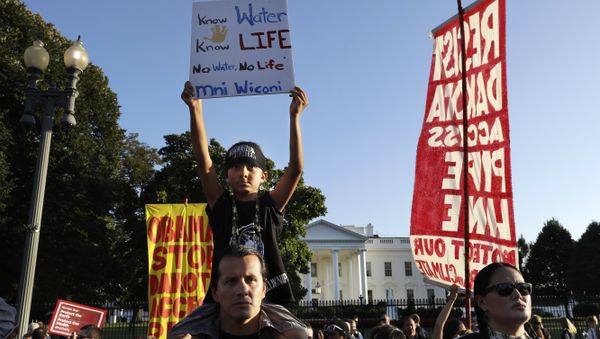 Omaka Nawicakincinji Mendoza, 7, holds a sign while on the shoulders of his father, Bill Mendoza, who is Oglala Lakota Nation and moved to Washington from Pine Ridge, S.D., as they attend a rally by the White House with members of the Standing Rock Sioux Tribe and other tribal nations and their supporters in opposition of the Dakota Access oil pipeline, Tuesday, Sept. 13, 2016, in Washington - Sputnik International