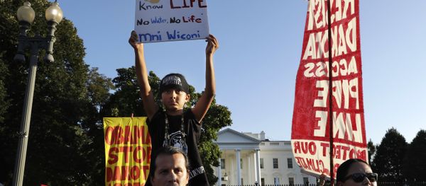 Omaka Nawicakincinji Mendoza, 7, holds a sign while on the shoulders of his father, Bill Mendoza, who is Oglala Lakota Nation and moved to Washington from Pine Ridge, S.D., as they attend a rally by the White House with members of the Standing Rock Sioux Tribe and other tribal nations and their supporters in opposition of the Dakota Access oil pipeline, Tuesday, Sept. 13, 2016, in Washington - Sputnik International