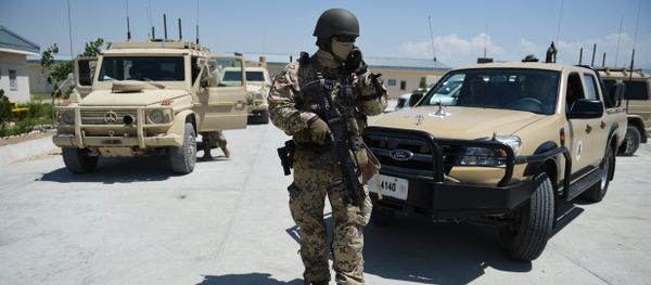 A German soldier from the NATO coalition stands guard during a visit by resolute support spokesman Brigadier General H. Cleveland outside the Shaheen 209th military corps training center in Mazar-i-Sharif on April 26, 2016 - Sputnik International