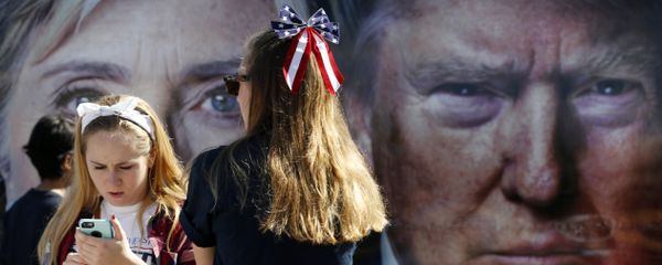 People pause near a bus adorned with large photos of candidates Hillary Clinton and Donald Trump before the presidential debate. People pause near a bus adorned with large photos of candidates Hillary Clinton and Donald Trump before the presidential debate. - Sputnik International