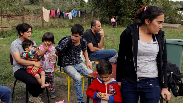 A group of people wait to get accommodation at the entrance of a camp for refugees and migrants in the Belgrade suburb of Krnjaca, Serbia, September 21, 2016. - Sputnik International