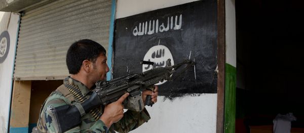 An Afghan soldier points his gun at Daesh militants group banner as he patrols during ongoing clashes in Kot District in eastern Nangarhar province - Sputnik International