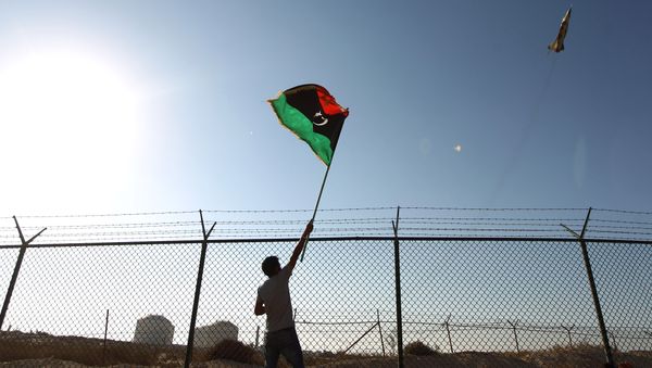 A man waves a Libyan flag A man waves a Libyan flag - Sputnik International