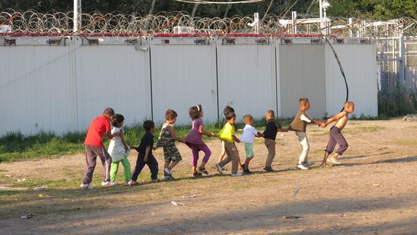 Boarders in Hungary stand tall as children play and attempt to try and live a normal life in the camp. Boarders in Hungary stand tall as children play and attempt to try and live a normal life in the camp. - Sputnik International
