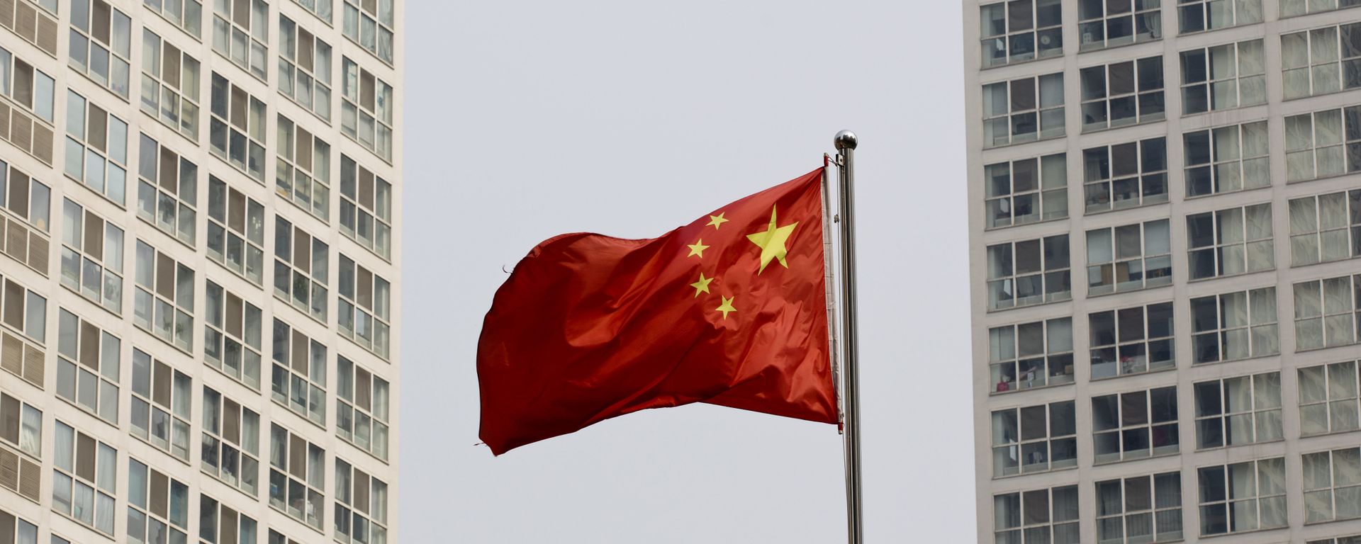 A Chinese national flag flutters in the wind in between a high-rise residential and office complex in Beijing, China. (File) A Chinese national flag flutters in the wind in between a high-rise residential and office complex in Beijing, China. (File) - Sputnik International, 1920, 24.02.2023