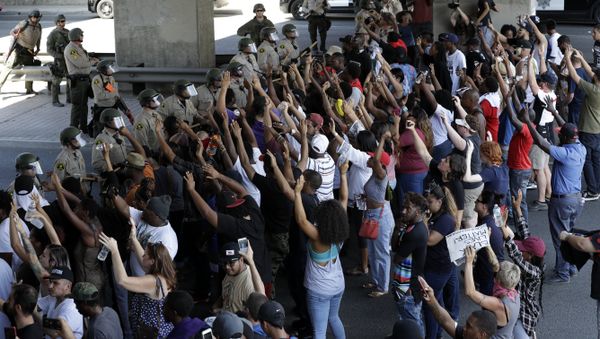 Police form a line in front of protesters, Wednesday, Sept. 28, 2016, in El Cajon, Calif. Dozens of demonstrators on Wednesday protested the killing of a black man shot by an officer after authorities said the man pulled an object from a pocket, pointed it and assumed a shooting stance. - Sputnik International