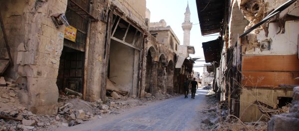 Syrian government soldiers walk in the damaged al-Farafira souk in the government-held side of Aleppo's historic city centre on September 16, 2016 - Sputnik International