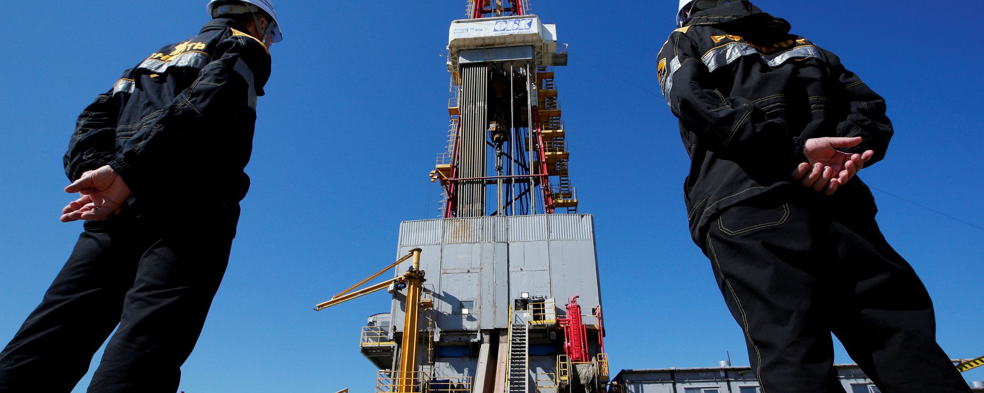 Workers look at a drilling rig at a well pad of the Rosneft-owned Prirazlomnoye oil field outside the West Siberian city of Nefteyugansk, Russia, August 4, 2016 - Sputnik International, 1920, 08.03.2022