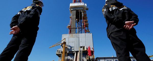 Workers look at a drilling rig at a well pad of the Rosneft-owned Prirazlomnoye oil field outside the West Siberian city of Nefteyugansk, Russia, August 4, 2016 - Sputnik International
