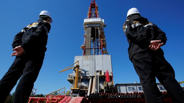 Workers look at a drilling rig at a well pad of the Rosneft-owned Prirazlomnoye oil field outside the West Siberian city of Nefteyugansk, Russia, August 4, 2016 - Sputnik International