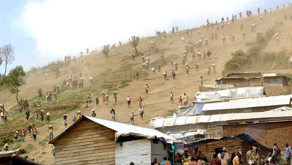 People carry bags of cassiterite (tin ore), coltan, which is used in mobile telephones and computers, and manganese down a hill from the Mudere mine, near Rubaya, some 9 kms from the eastern Democratic Republic of Congo city of Goma (File) - Sputnik International