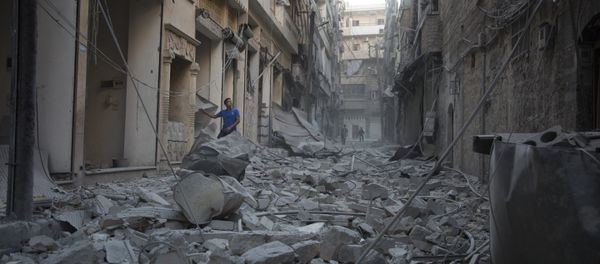 A Syrian man stands in the rubble of destroyed buildings following an air strike in Aleppo's rebel-controlled neighbourhood of Karm al-Jabal. (File) A Syrian man stands in the rubble of destroyed buildings following an air strike in Aleppo's rebel-controlled neighbourhood of Karm al-Jabal. (File) - Sputnik International