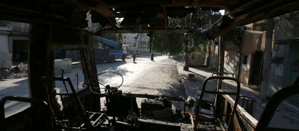 People walk past a burnt bus in the rebel held Seif al-Dawla neighbourhood of Aleppo, Syria October 6, 2016 People walk past a burnt bus in the rebel held Seif al-Dawla neighbourhood of Aleppo, Syria October 6, 2016 - Sputnik International