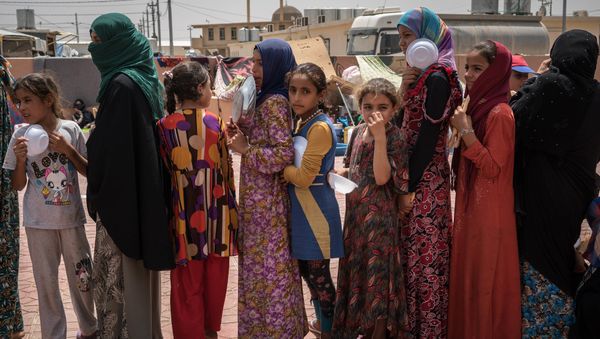 In this Aug. 7, 2016 file photo, women and children stand in line to receive a portion of food at Dibaga camp for internally displaced civilians in Iraq In this Aug. 7, 2016 file photo, women and children stand in line to receive a portion of food at Dibaga camp for internally displaced civilians in Iraq - Sputnik International