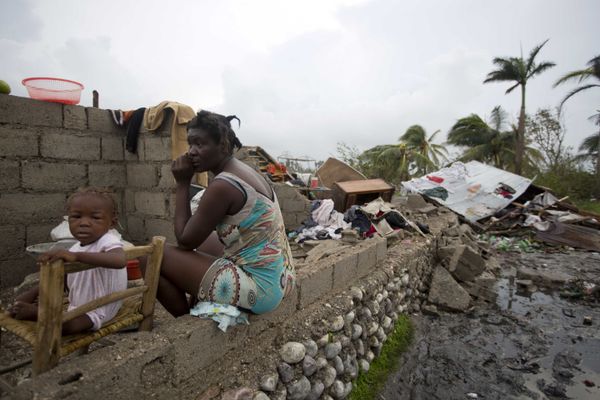 Victor Farah and her daughter sit in the ruins of their home destroyed by Hurricane Matthew in Les Cayes, Haiti, Thursday, Oct. 6, 2016. Two days after the storm rampaged across the country's remote southwestern peninsula, authorities and aid workers still lack a clear picture of what they fear is the country's biggest disaster in years. - Sputnik International