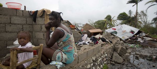 Victor Farah and her daughter sit in the ruins of their home destroyed by Hurricane Matthew in Les Cayes, Haiti, Thursday, Oct. 6, 2016. Two days after the storm rampaged across the country's remote southwestern peninsula, authorities and aid workers still lack a clear picture of what they fear is the country's biggest disaster in years. - Sputnik International