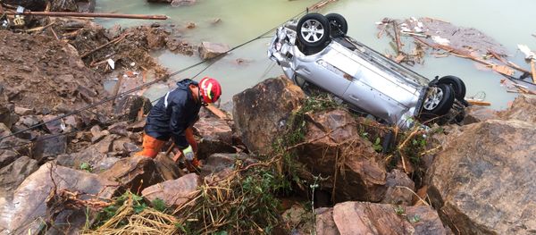 A rescue worker is seen next to an overturned car at the site of a landslide caused by heavy rains brought by Typhoon Megi, in Sucun Village, Lishui, Zhejiang province, China, September 29, 2016 - Sputnik International