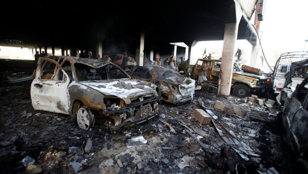 People stand at the site of an airstrike which witnesses said was by Saudi-led coalition aircraft on mourners at a hall where a wake for the father of Jalal al-Roweishan, the interior minister in the Houthi-dominated Yemeni government, was being held, in Sanaa, Yemen October 8, 2016 - Sputnik International