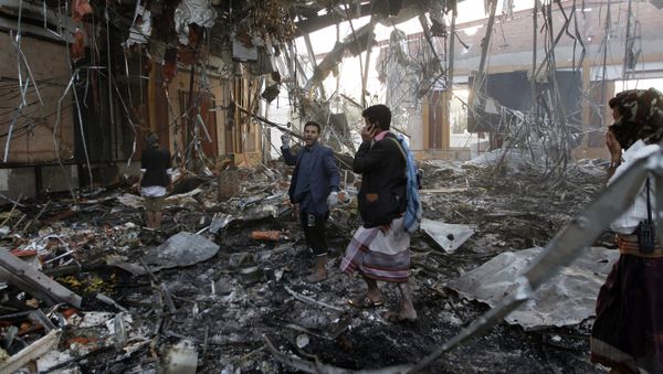 Yemeni rescue workers search for victims amid the rubble of a destroyed building following reported airstrikes by Saudi-led coalition air-planes on the capital Sanaa on October 8, 2016 - Sputnik International