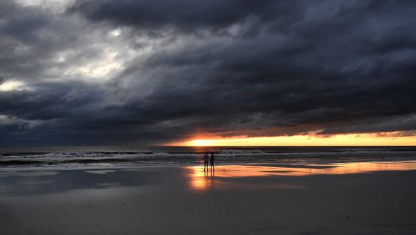 A couple watch the sunrise in Jacksonville Beach, Florida, on October 8, 2016, after Hurricane Matthew passed the area - Sputnik International