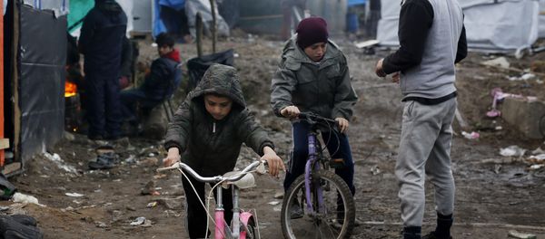 Afghan children ride their bicycles in a makeshift migrants camp near Calais, France, Thursday Feb. 25, 2016 Afghan children ride their bicycles in a makeshift migrants camp near Calais, France, Thursday Feb. 25, 2016 - Sputnik International