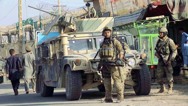Afghan security forces keep watch in front of their armoured vehicle in Kunduz city, Afghanistan October 4, 2016 - Sputnik International