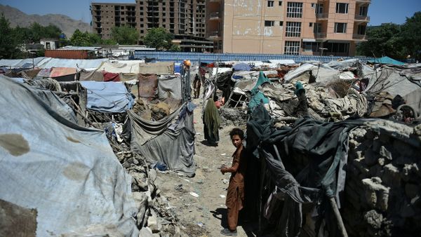Afghan child stands beside a shelter at a refugee camp in Kabul - Sputnik International