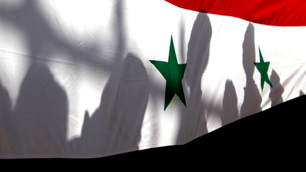 The shadows of people on a Syrian national flag are seen while they attend a peace march to mark International Day of Peace in Damascus. - Sputnik International