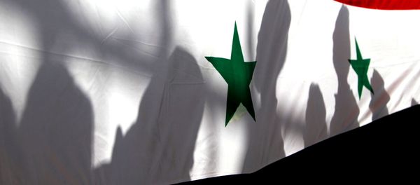 The shadows of people on a Syrian national flag are seen while they attend a peace march to mark International Day of Peace in Damascus. - Sputnik International