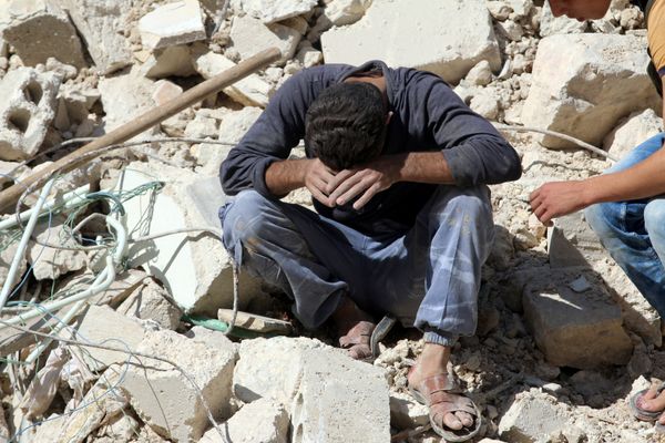 A man reacts on the rubble of damaged buildings after losing relatives to an airstrike in the besieged rebel-held al-Qaterji neighbourhood of Aleppo, Syria October 11, 2016.  - Sputnik International