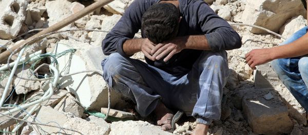 A man reacts on the rubble of damaged buildings after losing relatives to an airstrike in the besieged rebel-held al-Qaterji neighbourhood of Aleppo, Syria October 11, 2016. - Sputnik International