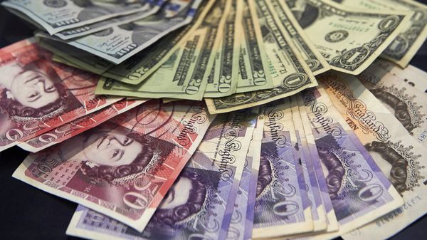 A cashier displays multiple denomination US dollar and British pound Sterling bank notes - Sputnik International