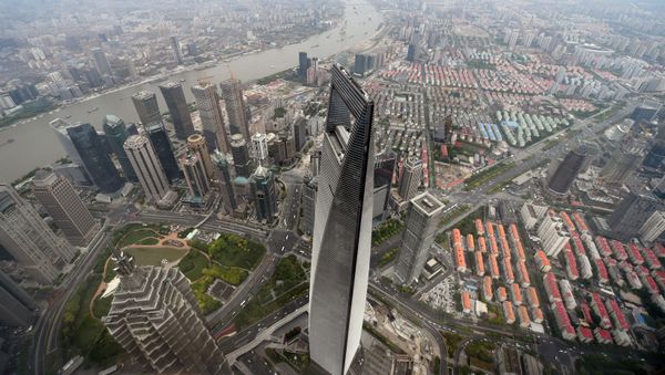 This picture taken on May 8, 2015 shows a view of the Shanghai World Financial Center (C) from the 120th floor of the new Shanghai Tower, which is still under construction.  The 632-metre Shanghai Tower (2,073 ft) is expected to be completed in the summer of 2015.   - Sputnik International