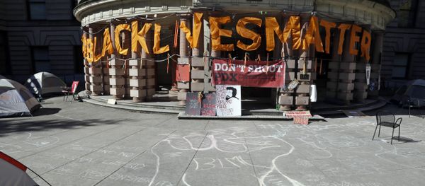 A raised raised is crawled in chalk as large letters saying Black Lives Matter hang on the portico at City Hall after the building was shut down due to a protest in Portland, Ore., Wednesday, Oct. 12, 2016. - Sputnik International