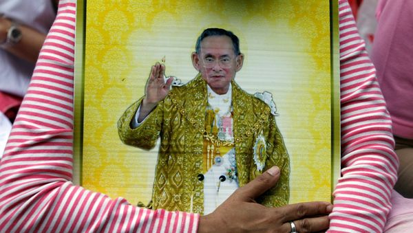 A well-wisher hugs a portrait of Thailand's King Bhumibol Adulyadej at the Siriraj hospital where he is residing in Bangkok, Thailand, October 13, 2016. - Sputnik International