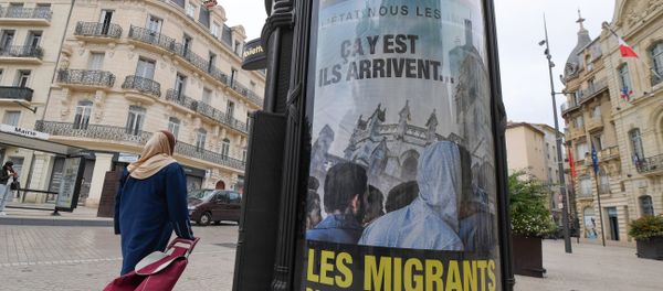 A woman walks by a poster reading They are coming, Migrants in our town centre in a street of Beziers, southern France, on October 12, 2016. A woman walks by a poster reading They are coming, Migrants in our town centre in a street of Beziers, southern France, on October 12, 2016. - Sputnik International