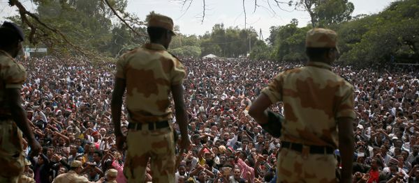 Police officers watch as demonstrators chant slogans while flashing the Oromo protest gesture during Irreecha, the thanksgiving festival of the Oromo people, in Bishoftu town, Oromia region, Ethiopia, October 2, 2016. - Sputnik International