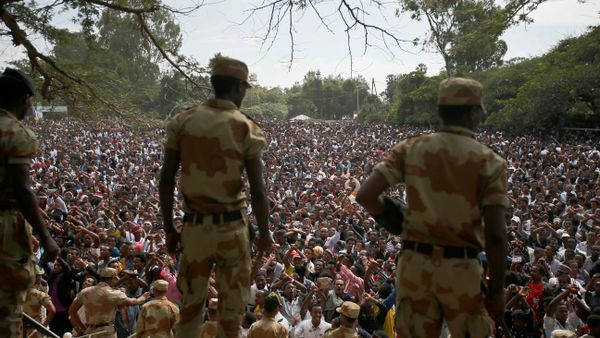 Police officers watch as demonstrators chant slogans while flashing the Oromo protest gesture during Irreecha, the thanksgiving festival of the Oromo people, in Bishoftu town, Oromia region, Ethiopia, October 2, 2016. - Sputnik International