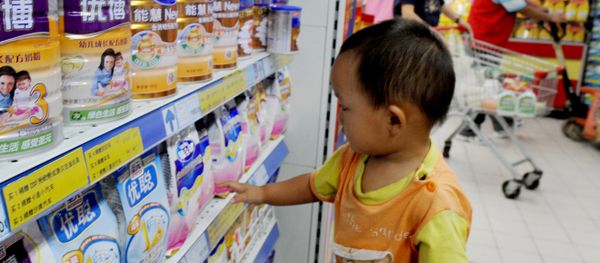A Chinese baby plays beside tins of milk powder made by NASDAQ-listed Synutra (L-1) on sale at a supermarket in Beijing on August 9, 2010 A Chinese baby plays beside tins of milk powder made by NASDAQ-listed Synutra (L-1) on sale at a supermarket in Beijing on August 9, 2010 - Sputnik International