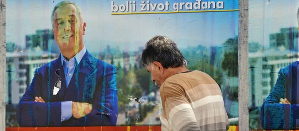 A man walks by election posters of Montenegrin Prime Minister Milo Djukanovic in Podgorica on October 14, 2016 A man walks by election posters of Montenegrin Prime Minister Milo Djukanovic in Podgorica on October 14, 2016 - Sputnik International