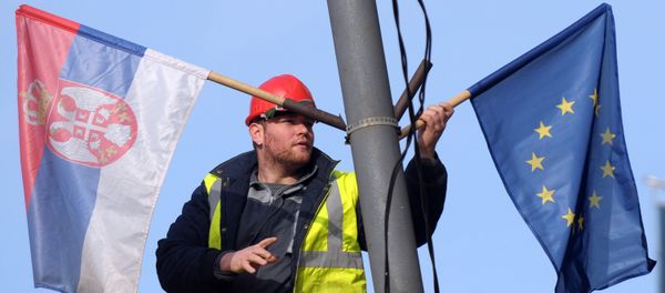 A worker arranges flags of Serbia and EU on a lamppost in Belgrade (File) A worker arranges flags of Serbia and EU on a lamppost in Belgrade (File) - Sputnik International