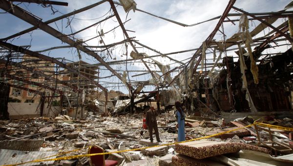 Member of the Specialized Criminal Prosecution Rajeh Zayed (L) responds to a call during a visit by human rights activists to a community hall that was struck by an air strike during a funeral on October 8, in Sanaa, Yemen, October 16, 2016 - Sputnik International
