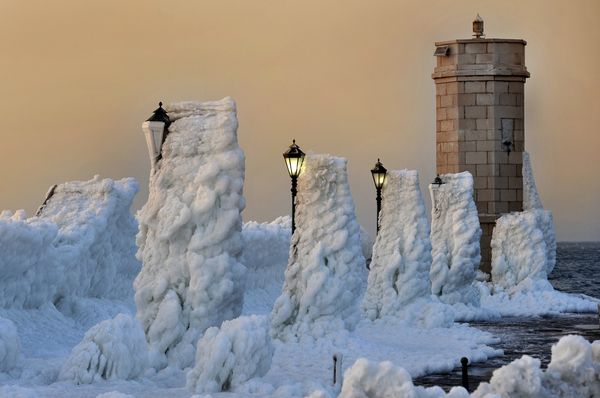 The harbour breakwater with lighthouse and lampposts is covered with heavy ice in the central Adriatic Croatian port of Senj, some 200 kilometres from Zagreb, as the sun sets on February 8, 2012. The harbour breakwater with lighthouse and lampposts is covered with heavy ice in the central Adriatic Croatian port of Senj, some 200 kilometres from Zagreb, as the sun sets on February 8, 2012. - Sputnik International