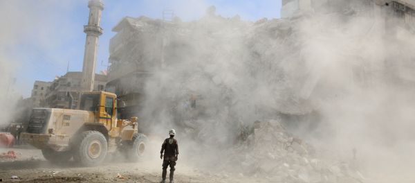 A Civil Defence member stands as a front loader removes debris after an air strike, Aleppo, Syria A Civil Defence member stands as a front loader removes debris after an air strike, Aleppo, Syria - Sputnik International