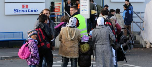 Migrants go to the ferry terminal to buy tickets at the port of Rostock, northeastern Germany - Sputnik International