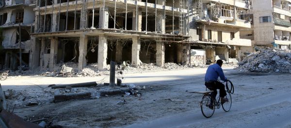 A man rides a bicycle near damaged buildings in the rebel held besieged al-Sukkari neighbourhood of Aleppo, Syria October 19, 2016. - Sputnik International