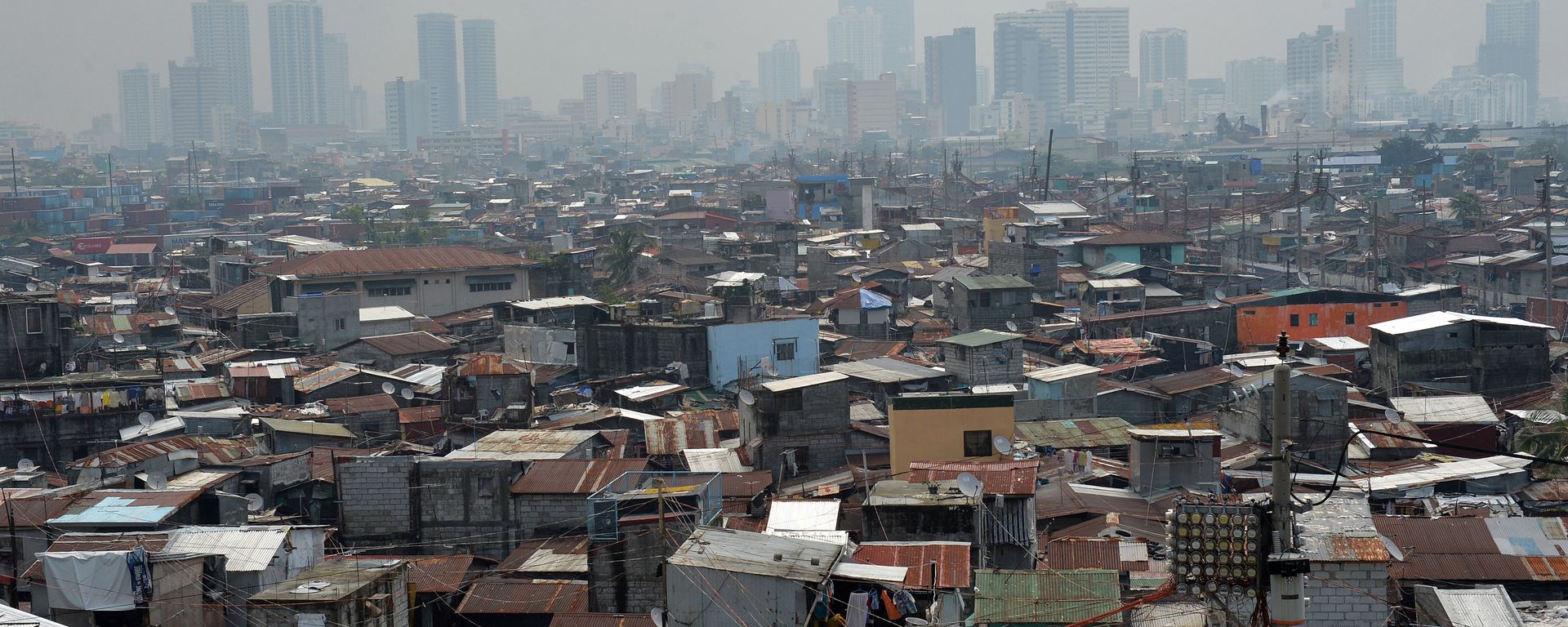 This general view shows informal settlers' homes (foreground) dwarped by highrise buildings in the background near the port of Manila - Sputnik International, 1920, 25.07.2022